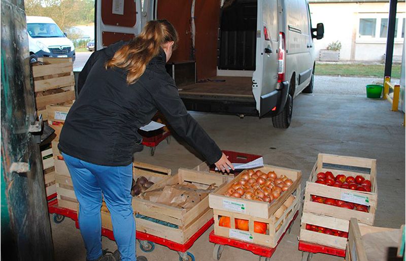 Femme déchargeant un camion de légumes